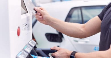 Man Charging Electric Vehicle Paying