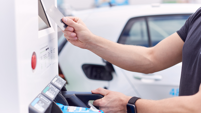 Man Charging Electric Vehicle Paying