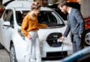 woman buying electric car showroom