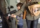 Mother and son charging electric car at home.