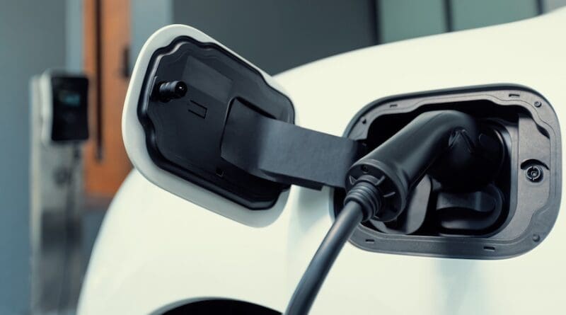 Closeup electric vehicle plugged-in with cable from charging point