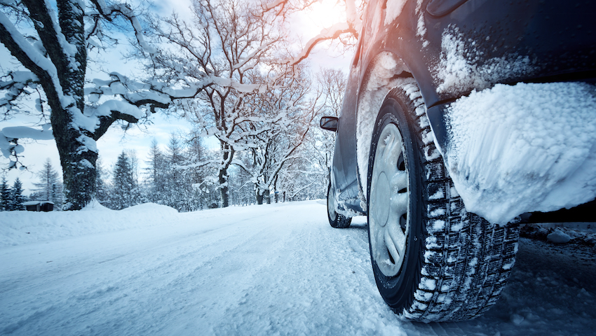 Car tires on winter road covered with snow