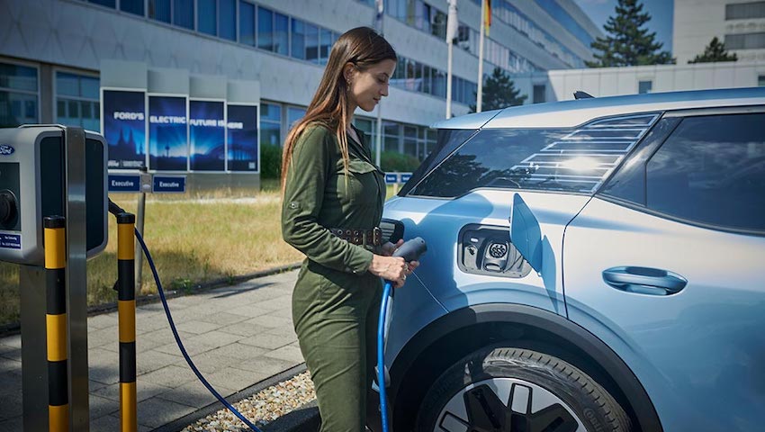 Adventure travel content creator Lexie Alford charging electric Ford Explorer