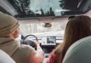 Couple driving in electric car go on a road trip.