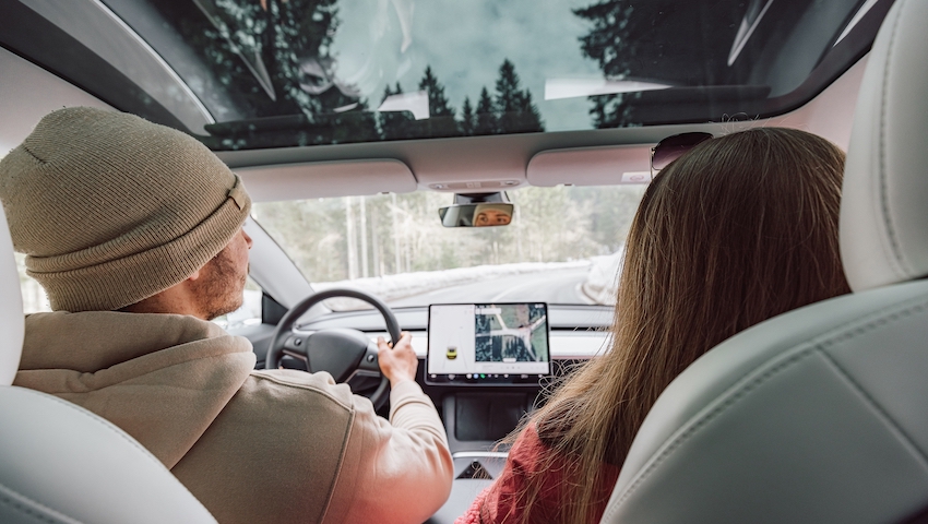 Couple driving in electric car go on a road trip.