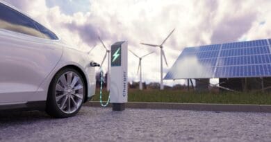 Using of charge station, solar panel and windmill background.