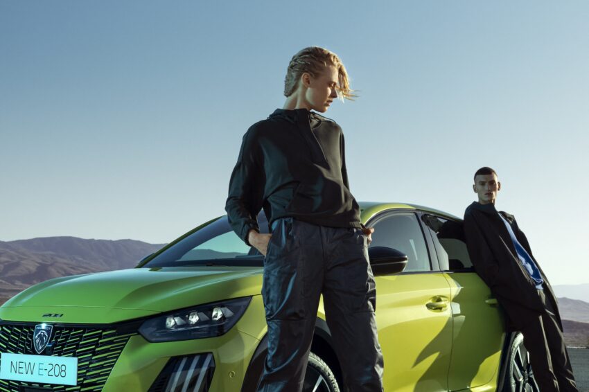 two young men with peugeot e-208 to illustrate driver ignorance of evs