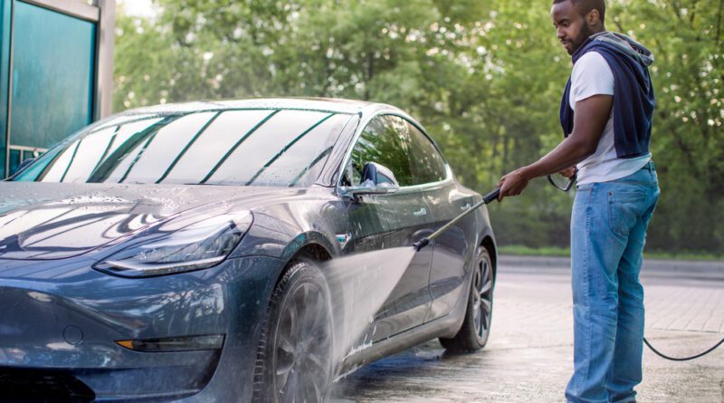 Driver washing an electric car